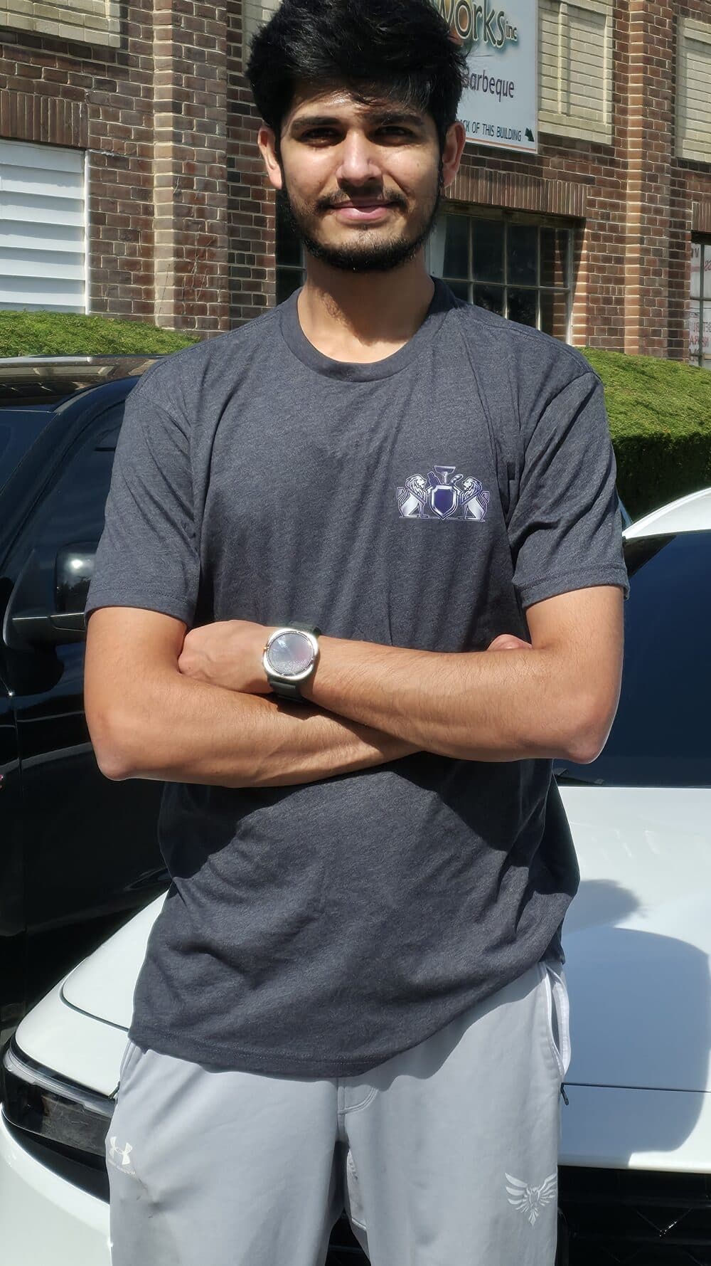 Mr. G, owner of Mr. G's Auto Care, standing with arms crossed in front of a freshly detailed white Honda in Westminster, MD