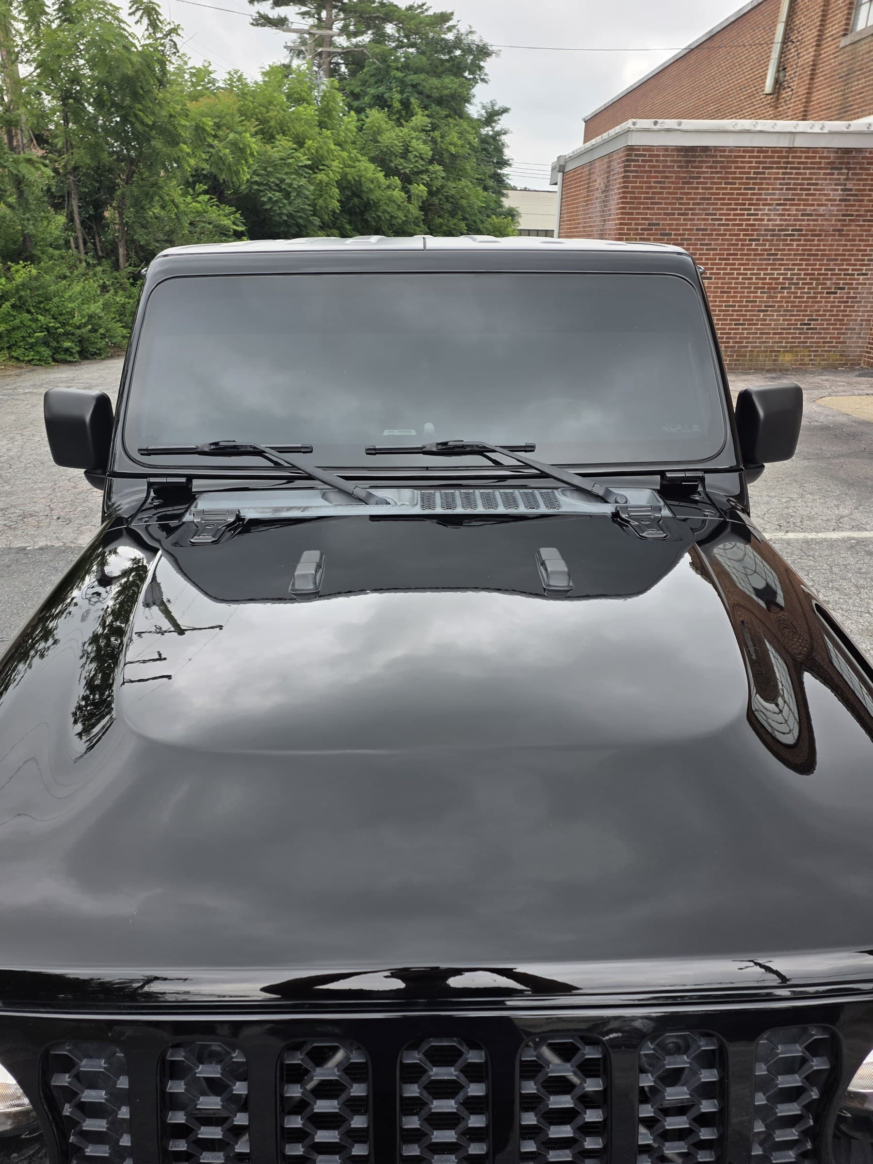 The glossy black hood and front end of a Jeep Gladiator after a full detail at Mr. G's Auto Care in Westminster, MD